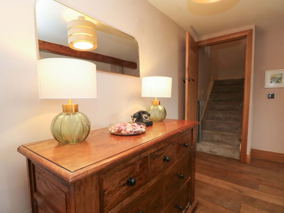 A hallway with a console table and lamps at Stone & Fleece Cottage in Holmbridge