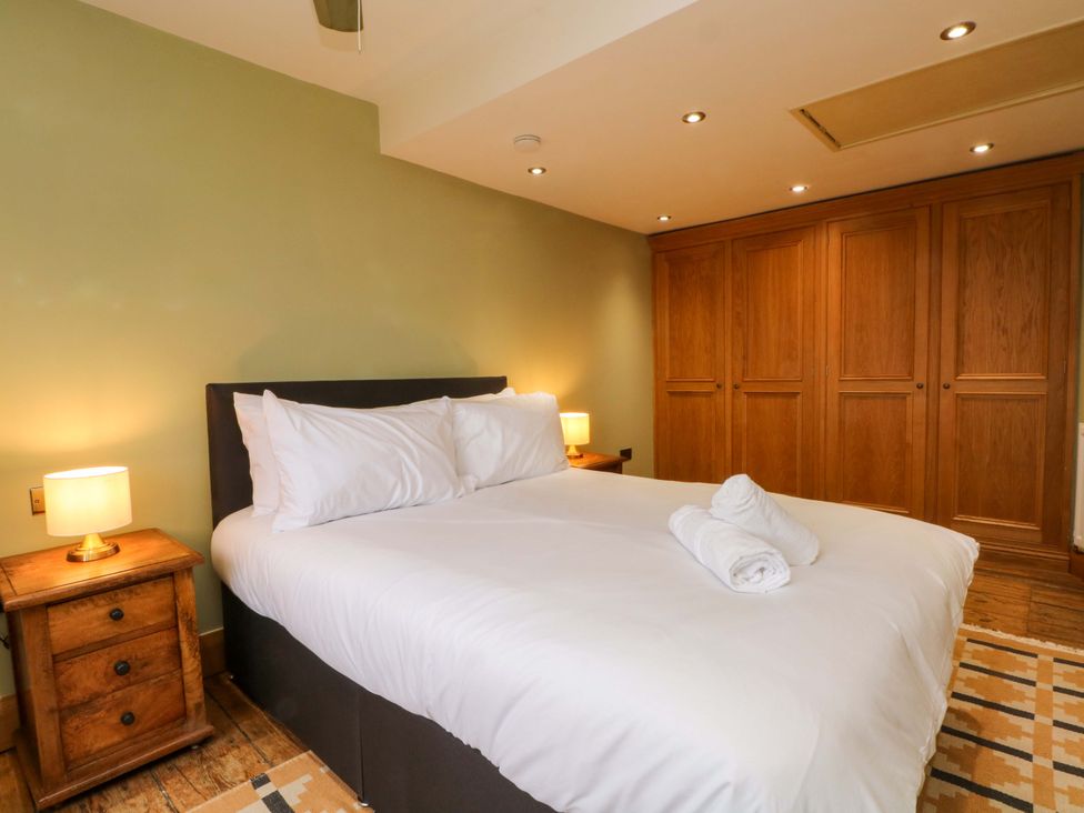 A bedroom with a bed and nightstand at Stone & Fleece Cottage in Holmbridge