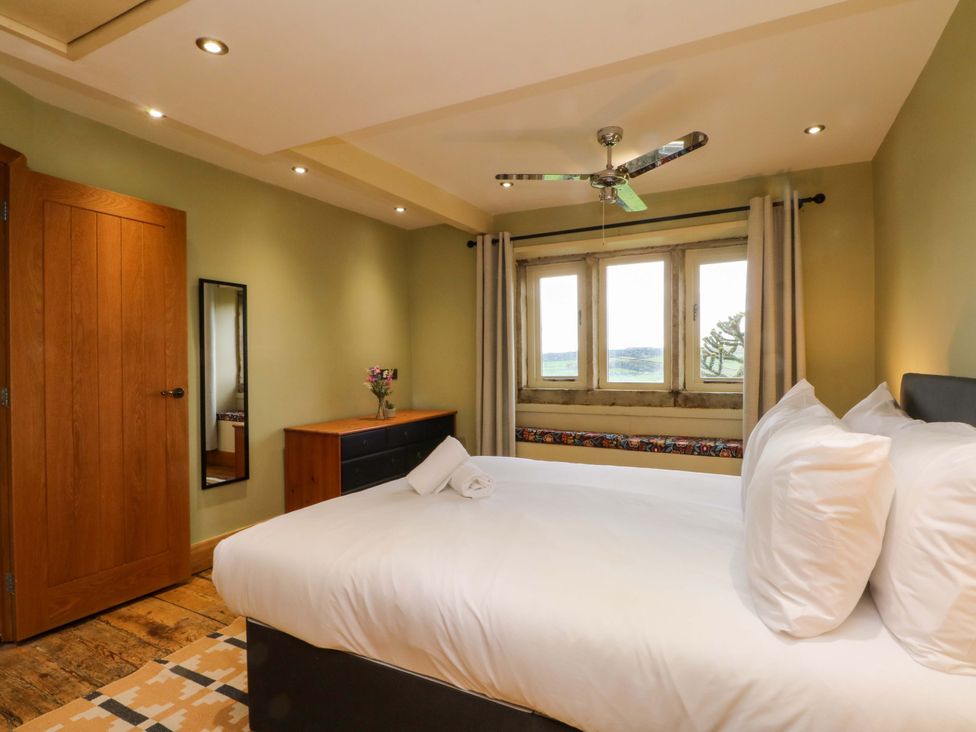 A bedroom with a bed and a window at Stone & Fleece Cottage Holmbridge
