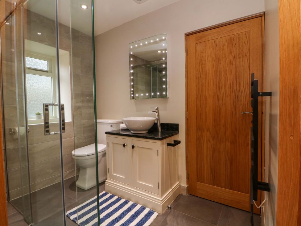 A bathroom with a shower and sink at Stone & Fleece Cottage in Holmbridge