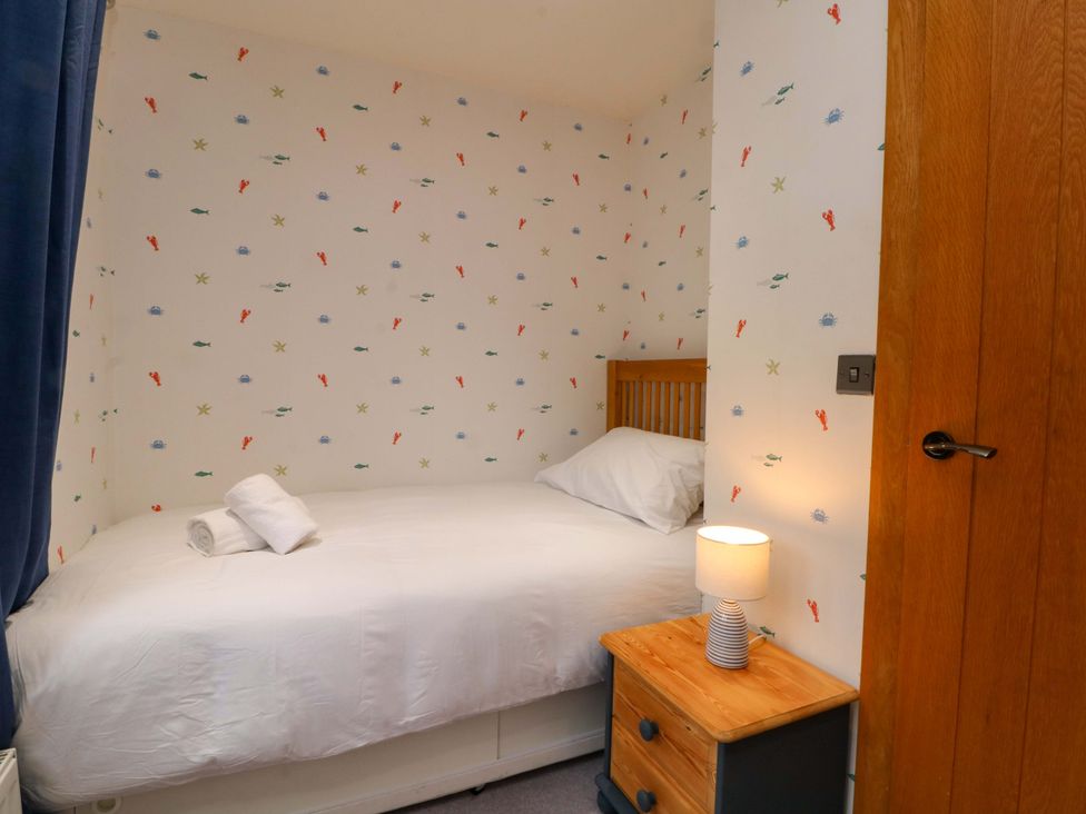 A bedroom with a single bed and a nightstand at Stone & Fleece Cottage in Holmbridge