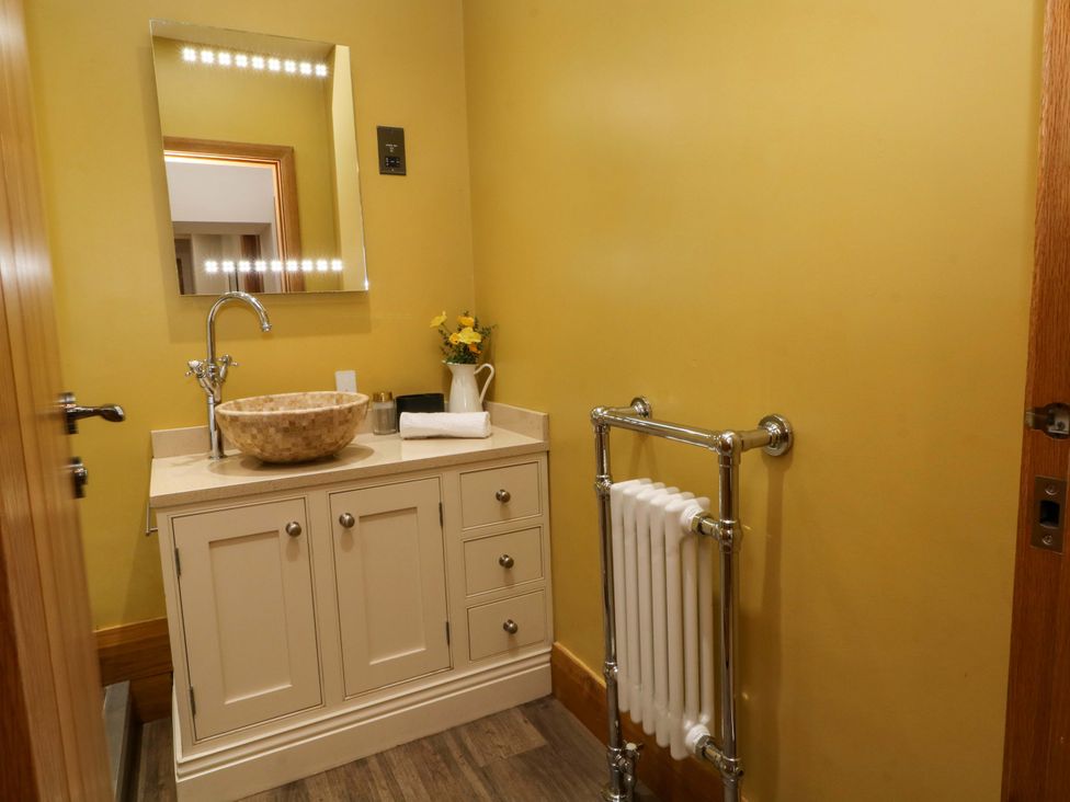 A bathroom with a wash basin and mirror at Stone & Fleece Cottage in Holmbridge