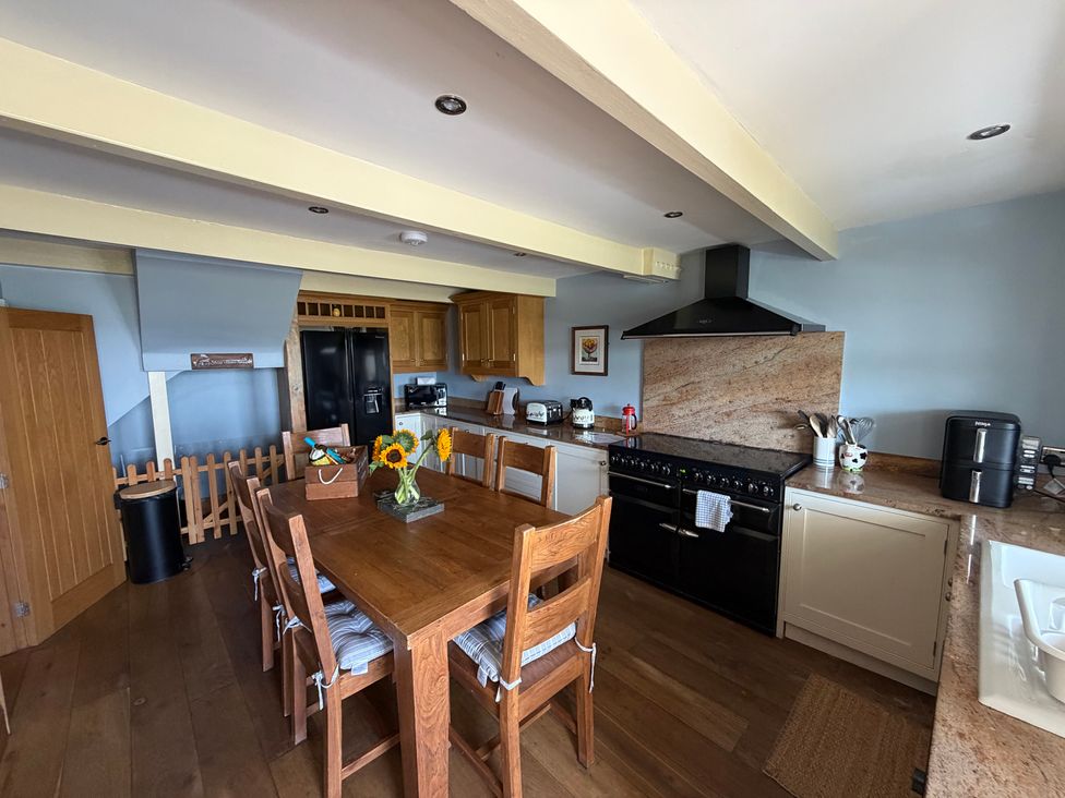 A kitchen with wooden table and chairs at Stone & Fleece Cottage in Holmfirth