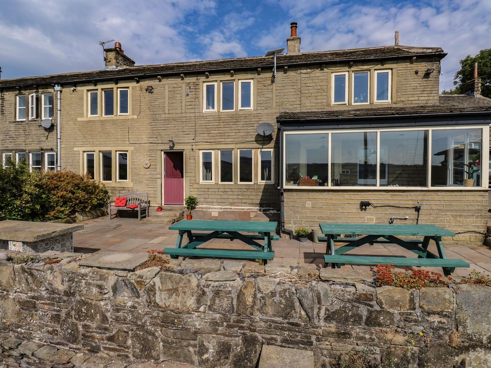 An outdoor area with benches and tables at Stone & Fleece Cottage in Holmfirth