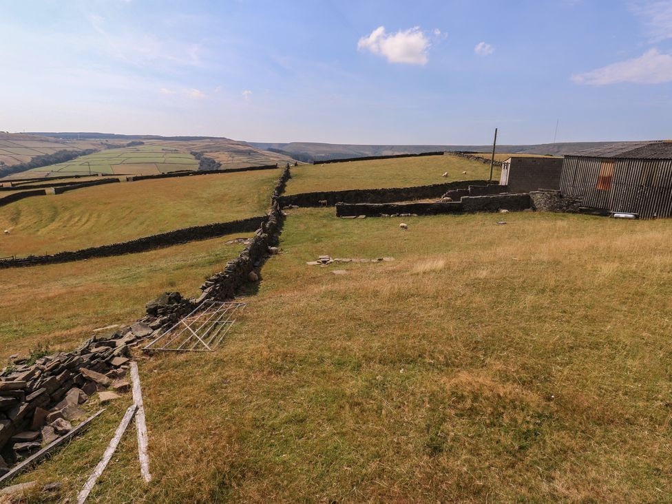 An outdoor view with fields and a stone wall at Stone & Fleece Cottage in Holmfirth