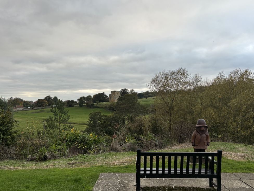 A bench and statue overlooking a field at 32 Castlegate East Ayton