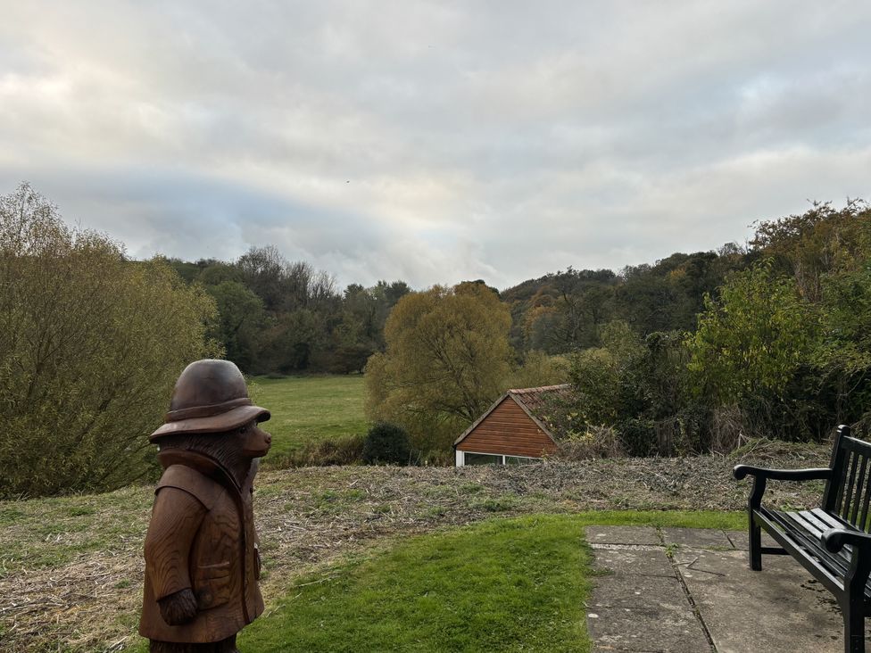 A wooden sculpture and a bench near a field at 32 Castlegate East Ayton