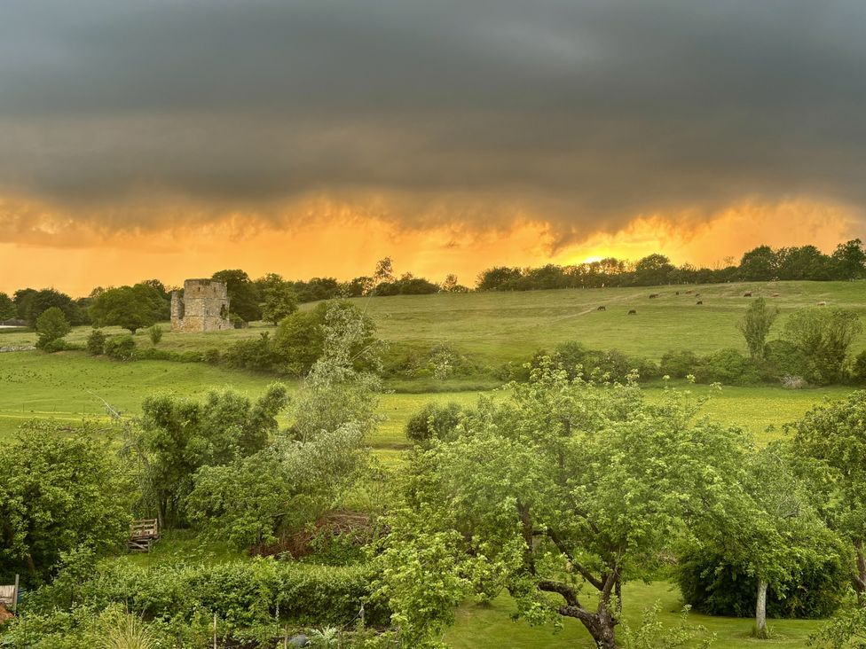 A landscape with ruins and cattle in the fields at 32 Castlegate East Ayton