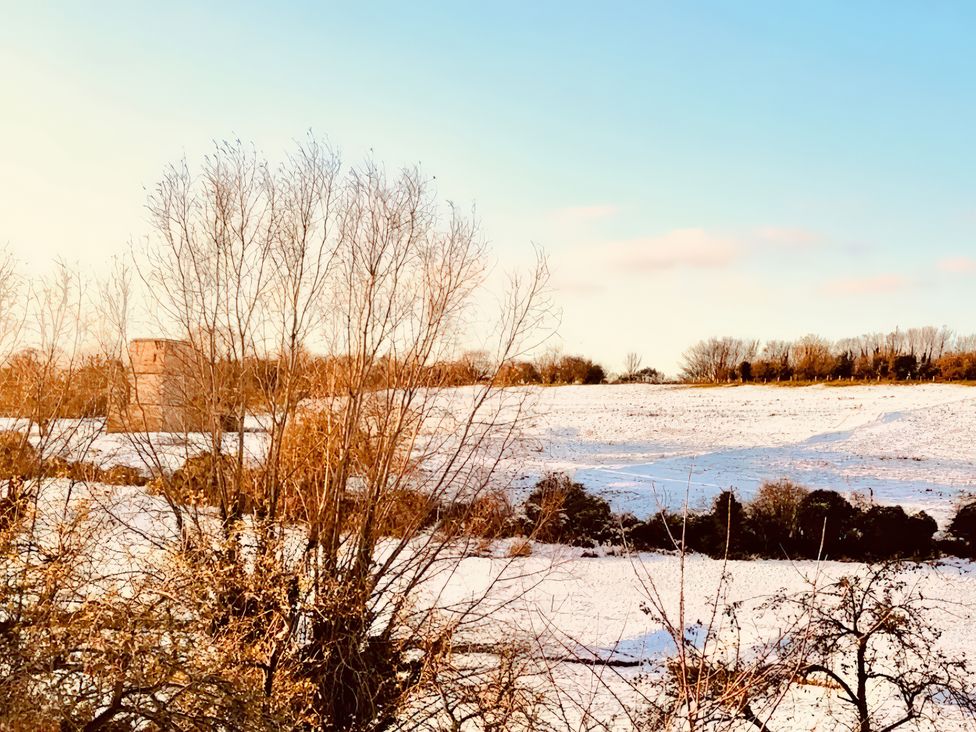A snowy field with trees and a building at 32 Castlegate in East Ayton