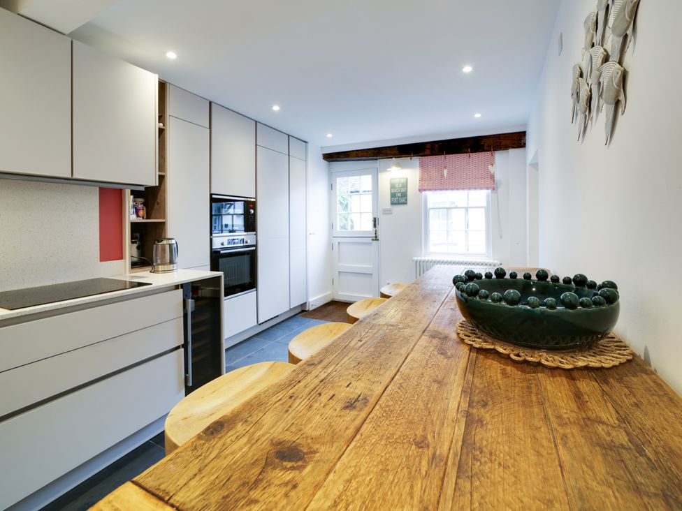 A kitchen with a wooden table and chairs at Church Hill House Port Isaac