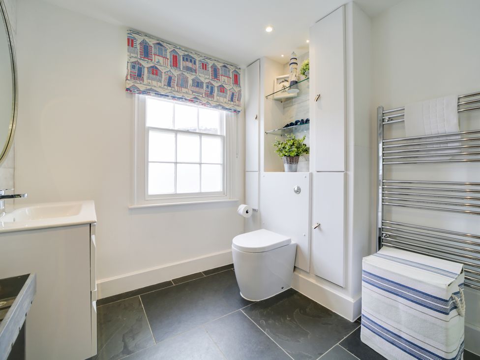 A bathroom with a toilet, sink, and towel rail at Church Hill House in Port Isaac