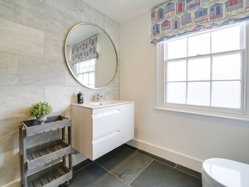 A bathroom with a mirror and sink at Church Hill House in Port Isaac