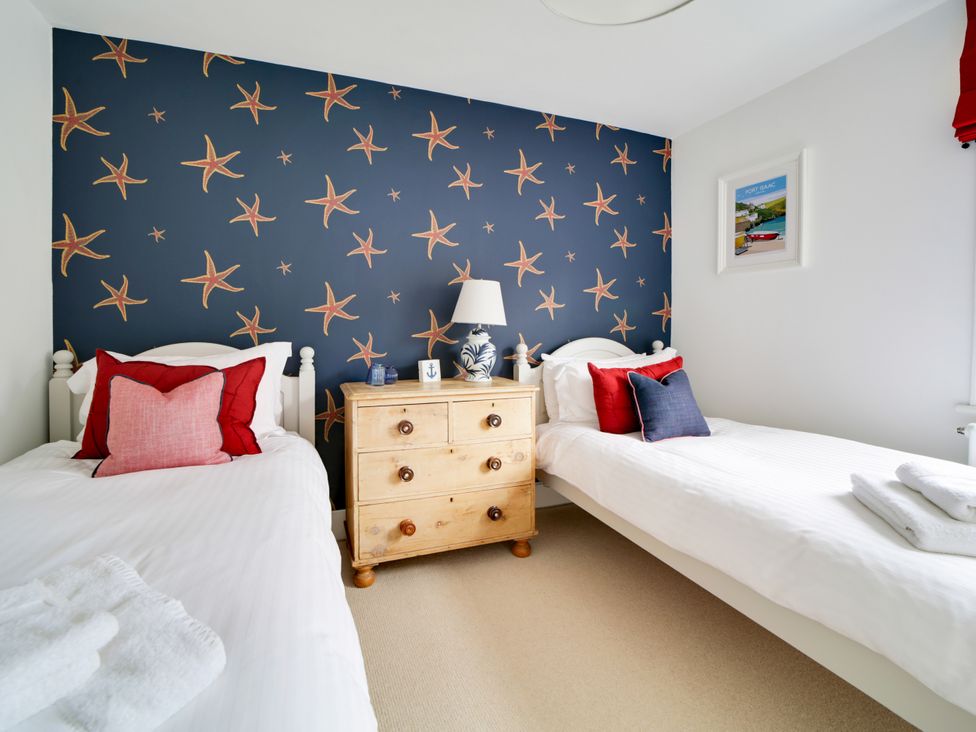 A bedroom with two beds and a chest of drawers at Church Hill House in Port Isaac