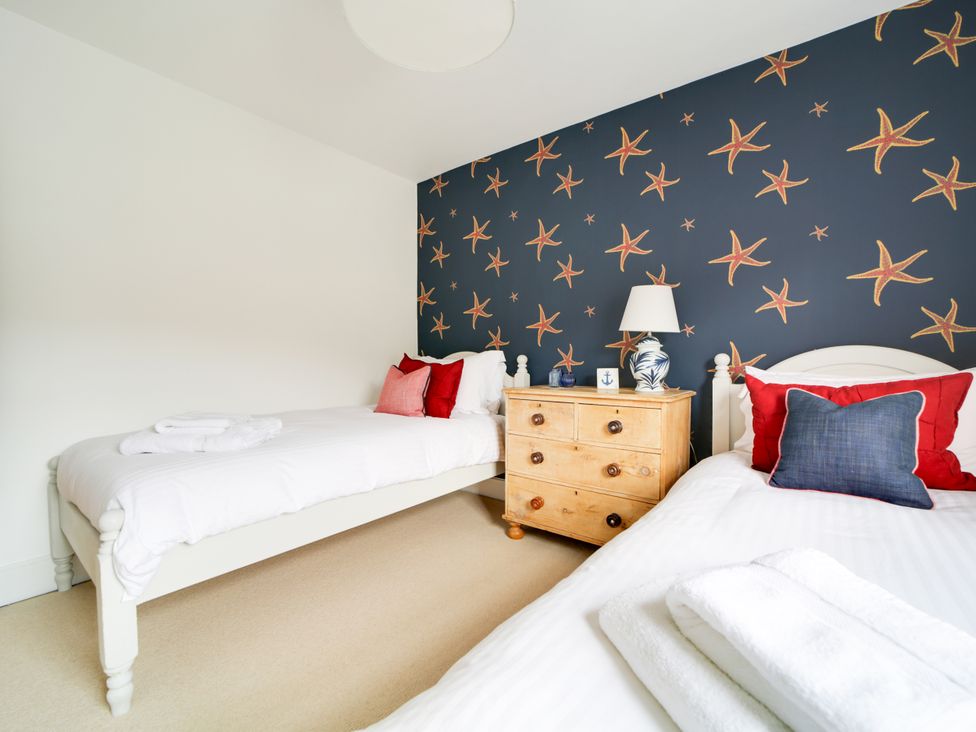 A bedroom with two beds and a dresser at Church Hill House in Port Isaac