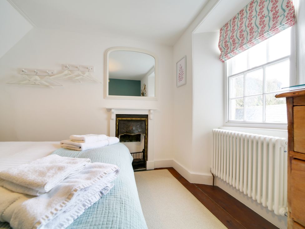 A bedroom with a bed and a mirror at Church Hill House Port Isaac