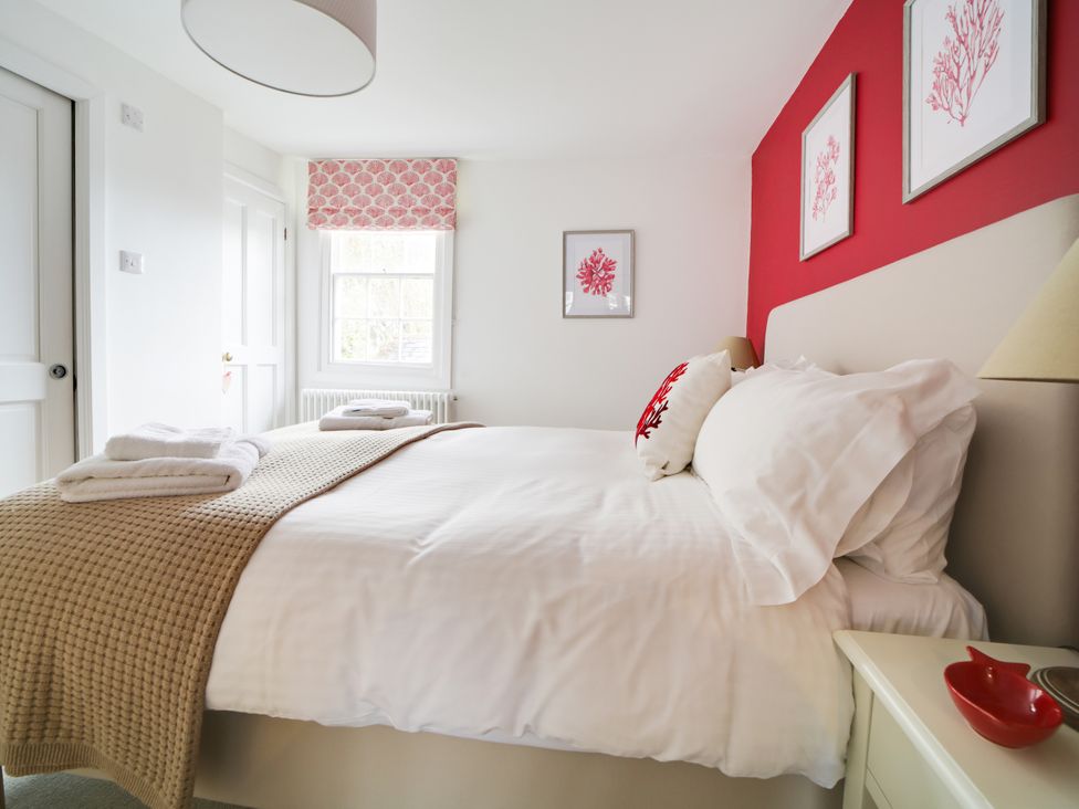 A bedroom with a bed and decorative elements at Church Hill House in Port Isaac