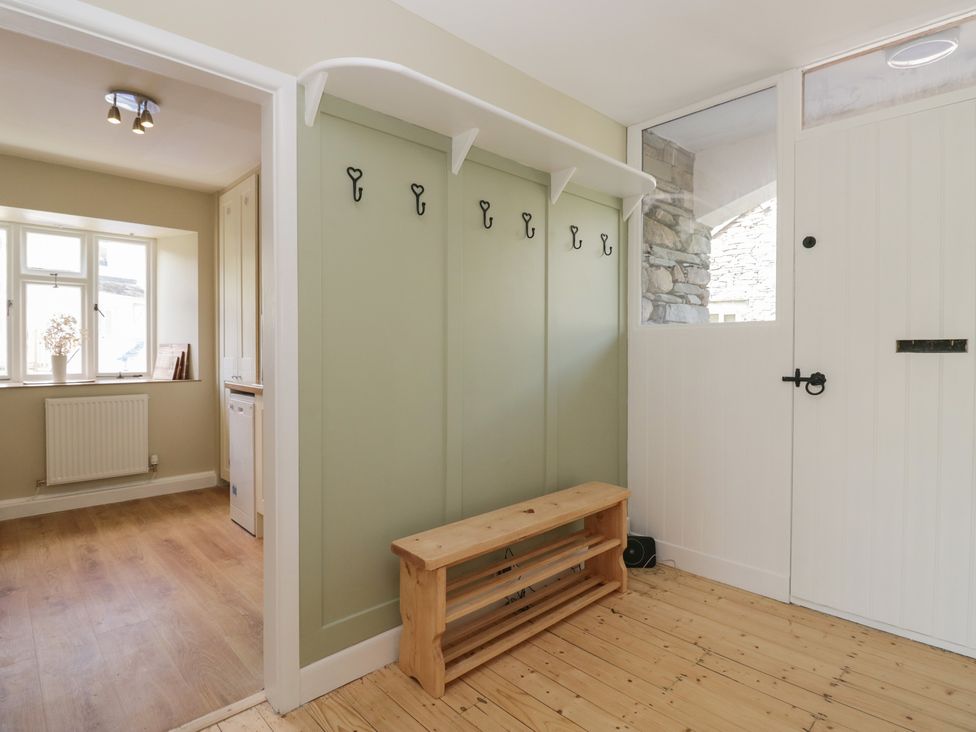 A hallway with coat hooks and a bench at The Barn at Grasmere