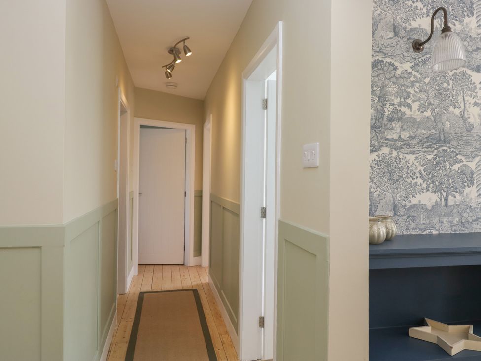 A hallway with light fixtures and decorative wallpaper at The Barn at Grasmere