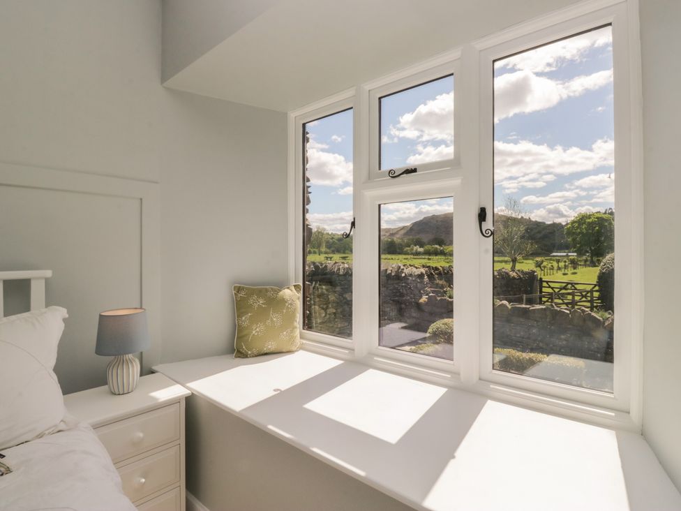 A bedroom with a window and lamp at The Barn at Grasmere in Grasmere