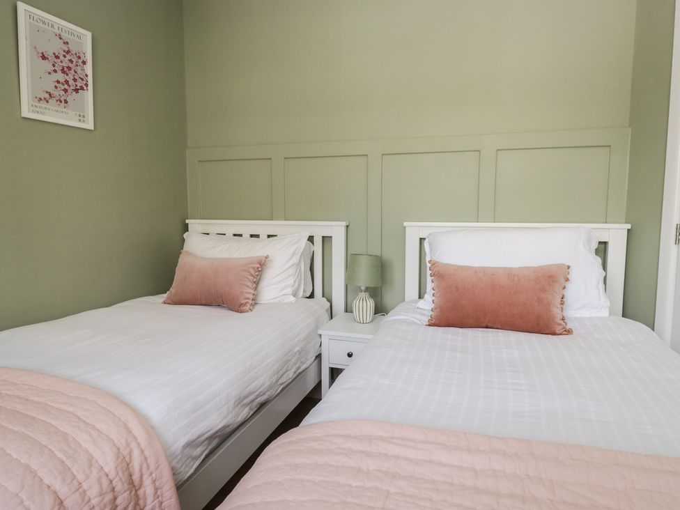 A bedroom with two beds and a lamp at The Barn at Grasmere