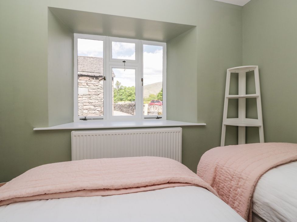 A bedroom with beds and a window at The Barn at Grasmere