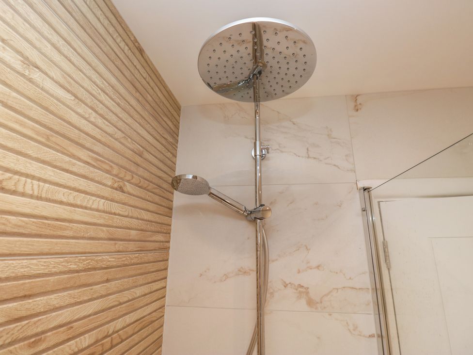 A shower with a fixed showerhead and a handheld shower at The Barn at Grasmere