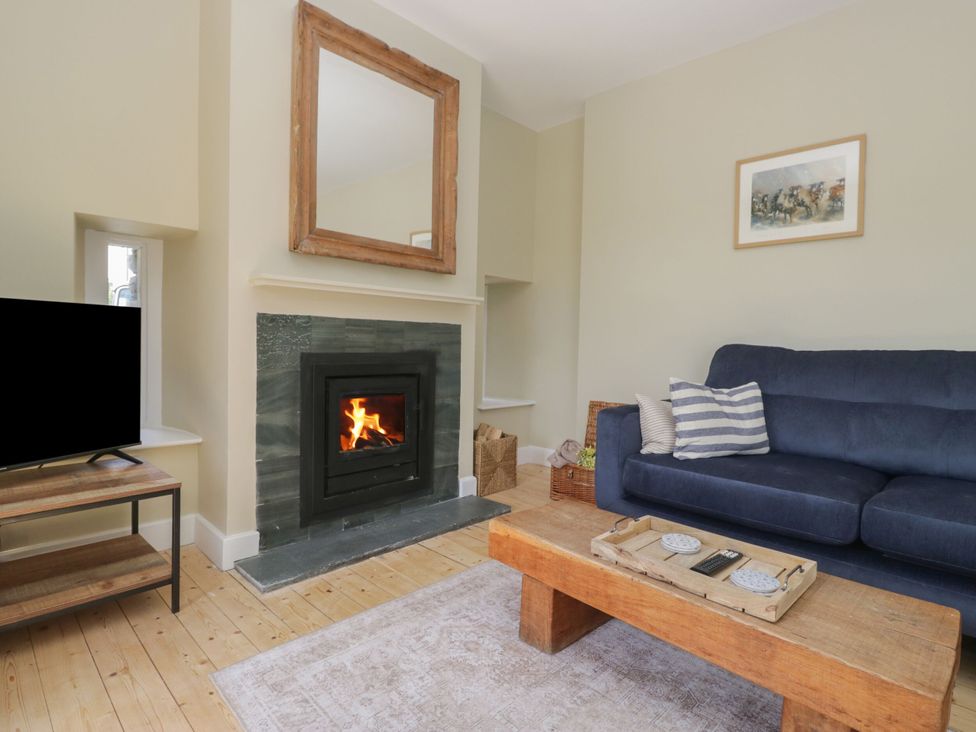 A living room with a fireplace and television at The Barn at Grasmere in Grasmere