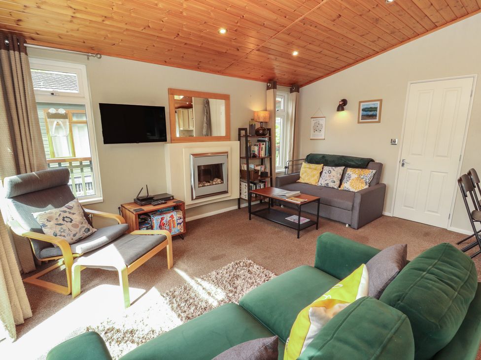 A living room with a sofa and fireplace at 28 Troutbeck in Bassenthwaite