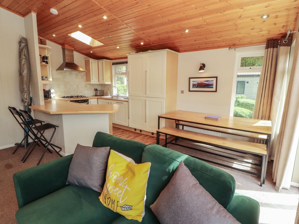A living room with a kitchen and dining table at 28 Troutbeck in Bassenthwaite