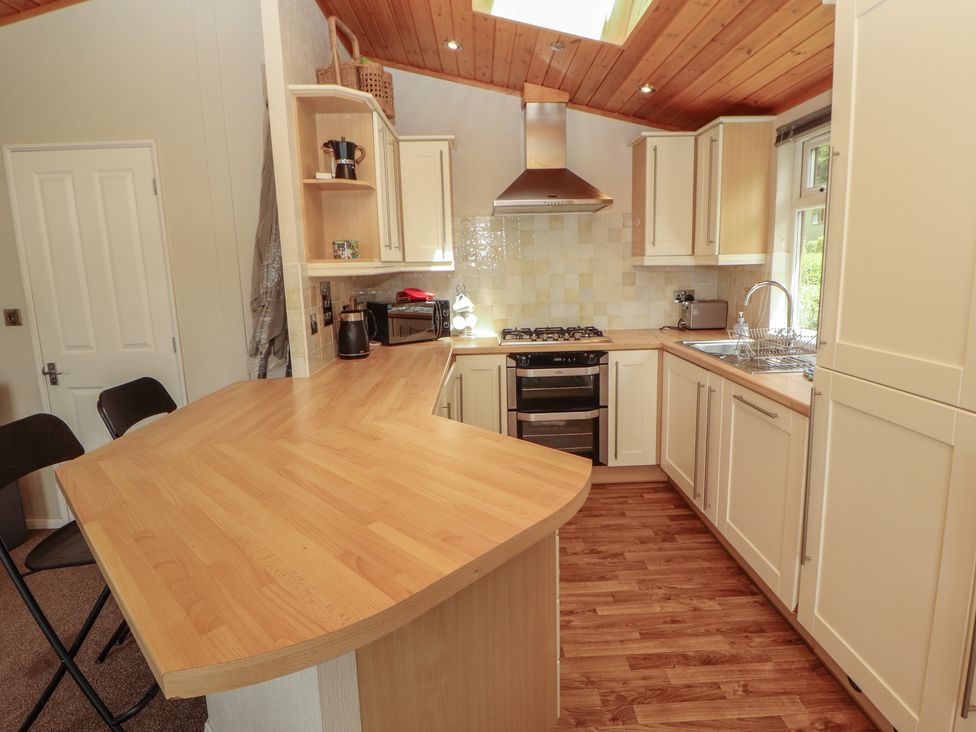 A kitchen with cabinets, stove, and sink at 28 Troutbeck in Bassenthwaite