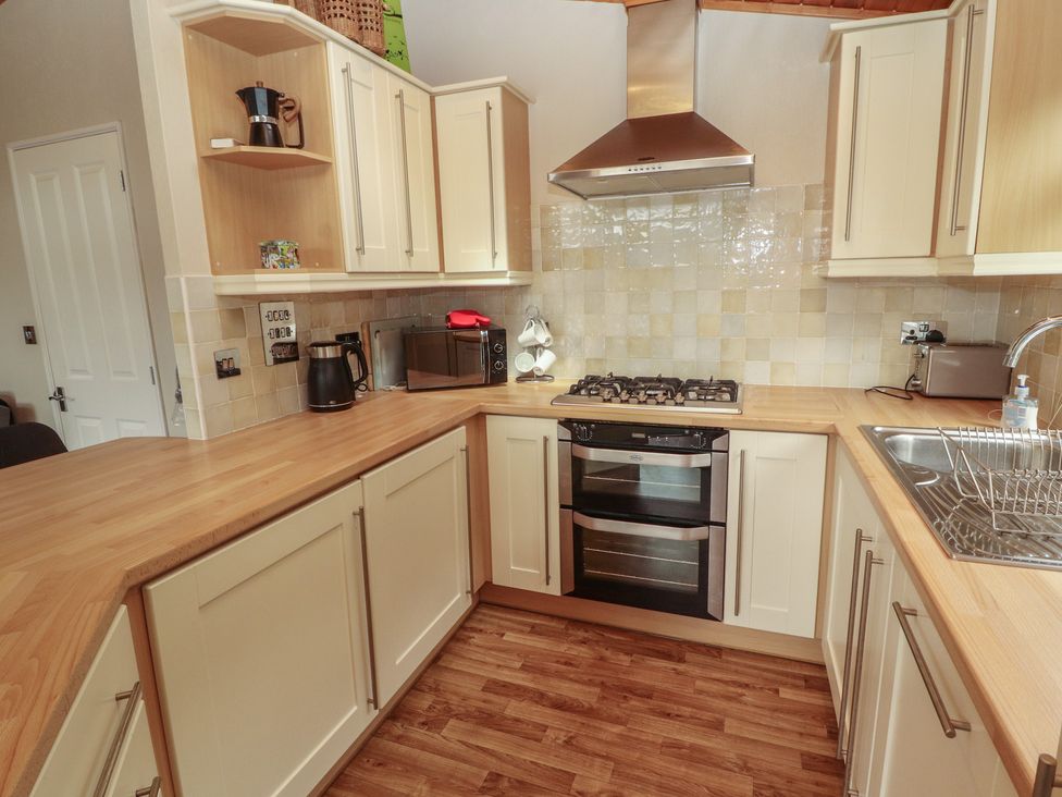A kitchen with a cooktop, oven, and microwave at 28 Troutbeck in Bassenthwaite