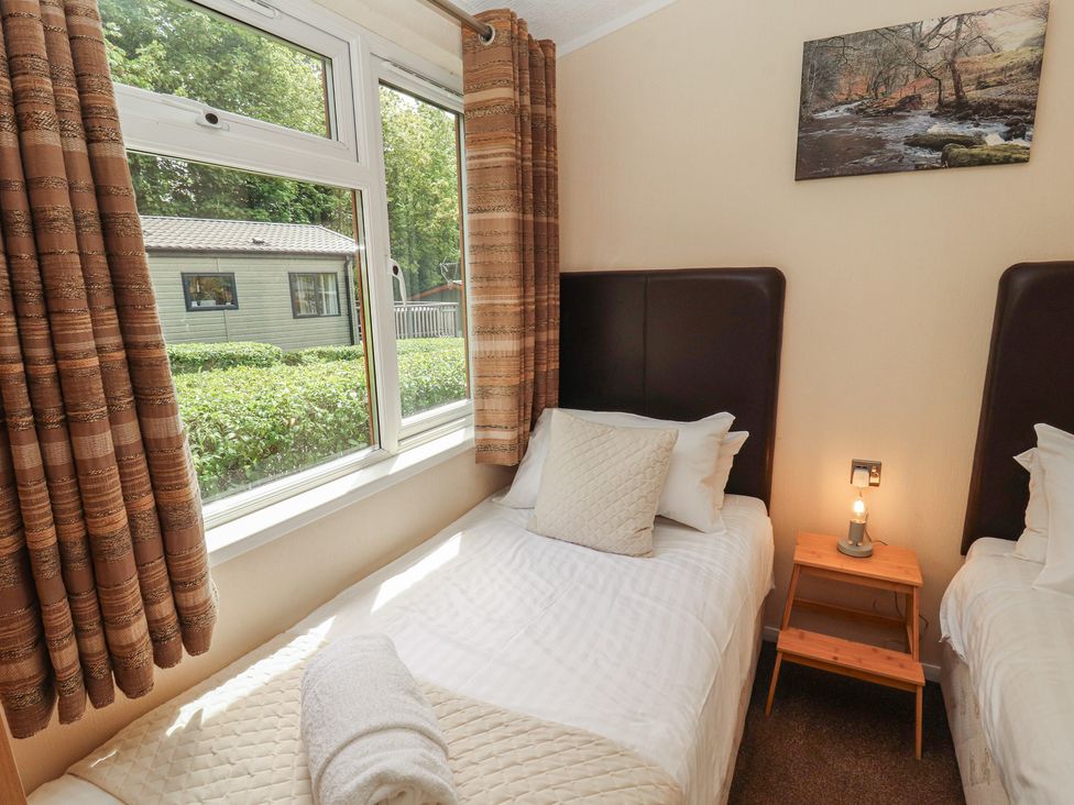 A bedroom with two single beds and a window at 28 Troutbeck in Bassenthwaite