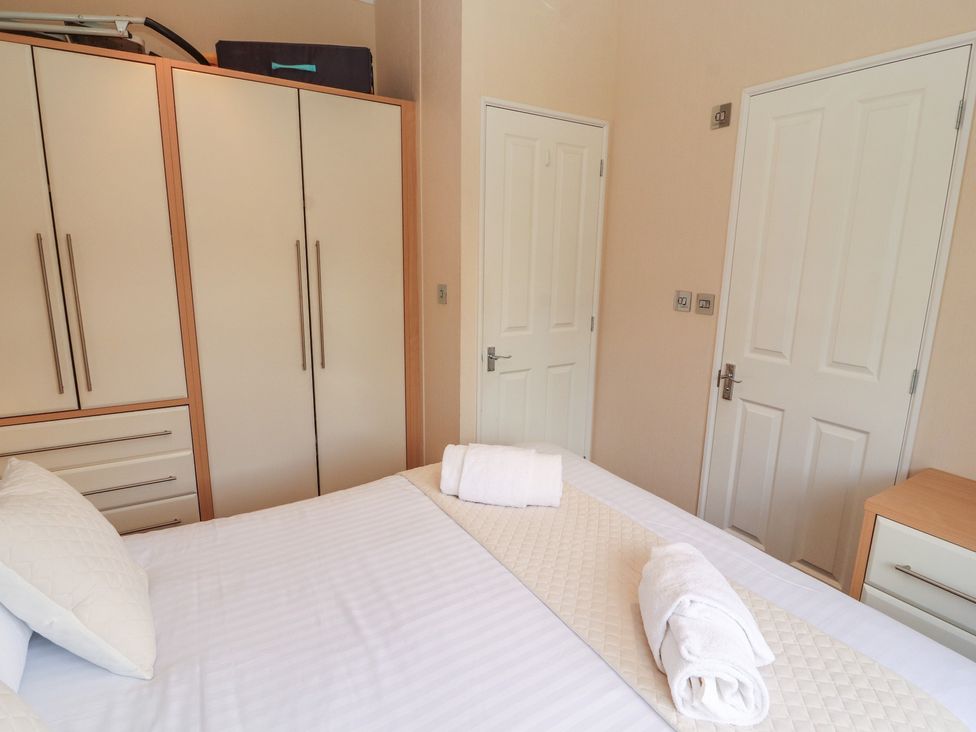 A bedroom with a bed and wardrobe at 28 Troutbeck in Bassenthwaite