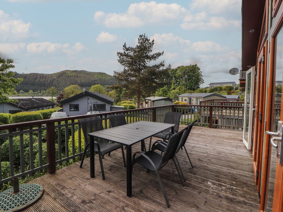 An outdoor patio with a table and chairs overlooking hills at 28 Troutbeck in Bassenthwaite