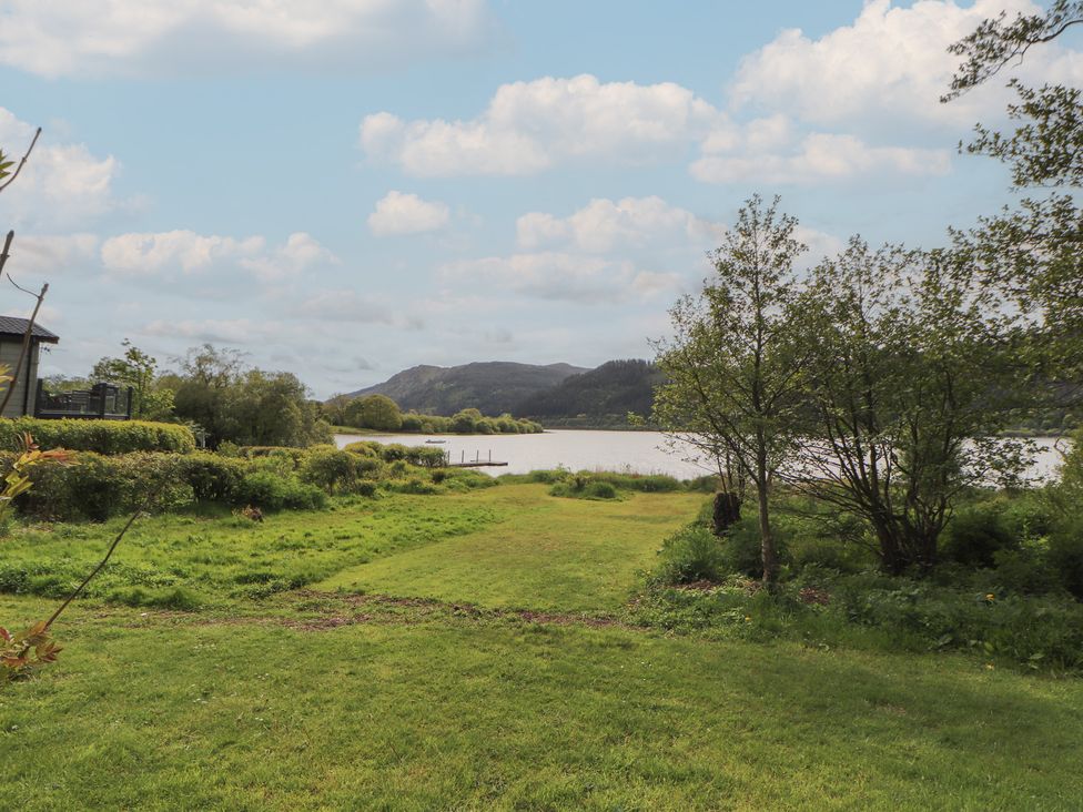 A view of a lake surrounded by grass and trees at 28 Troutbeck in Bassenthwaite