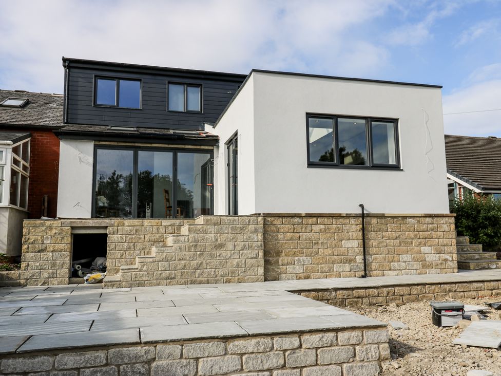 An outdoor view of a house with a staircase at 489 New Hey Road in Huddersfield