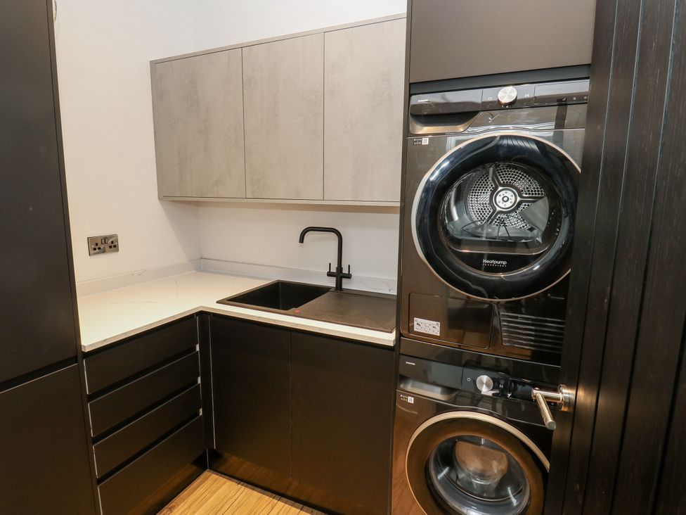 A laundry room with a washing machine and dryer at 489 New Hey Road in Huddersfield