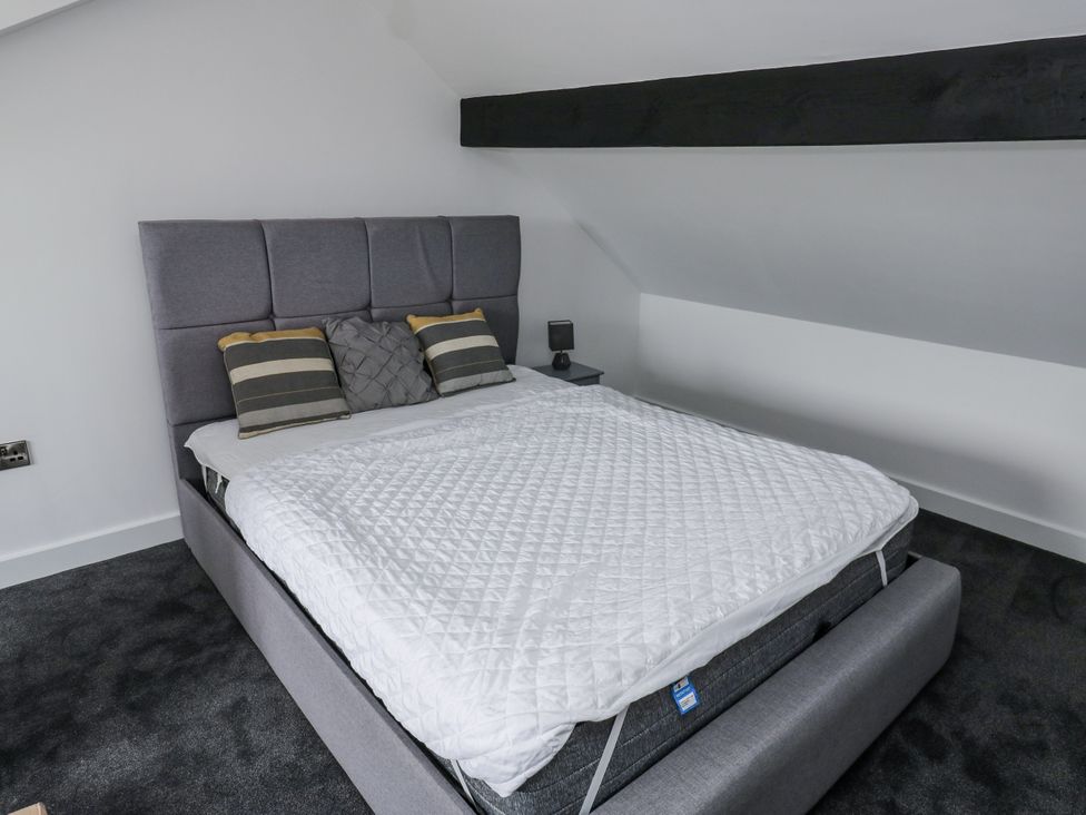 A bedroom with a bed and bedside table at 489 New Hey Road in Huddersfield