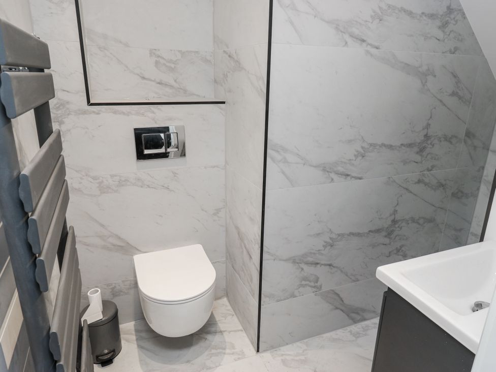 A bathroom with a shower, toilet, and sink at 489 New Hey Road in Huddersfield