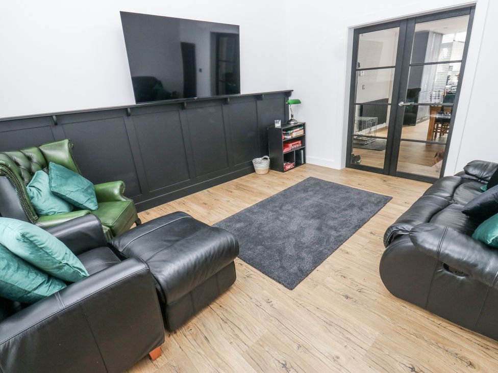 A living room with a television and seating at Ellis House in Huddersfield