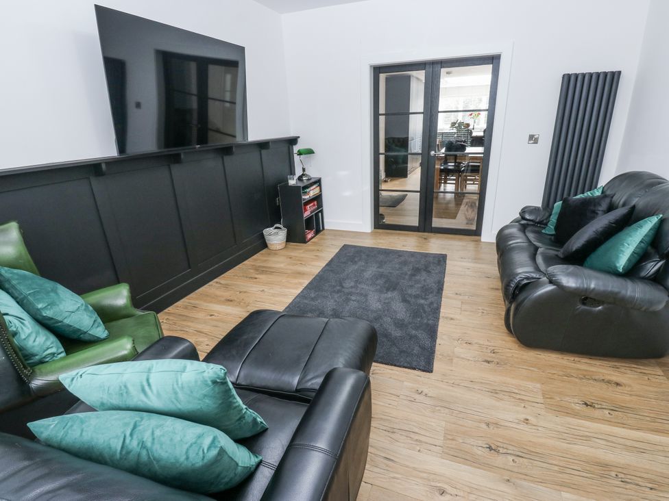 A living room with sofas and a television at Ellis House in Huddersfield