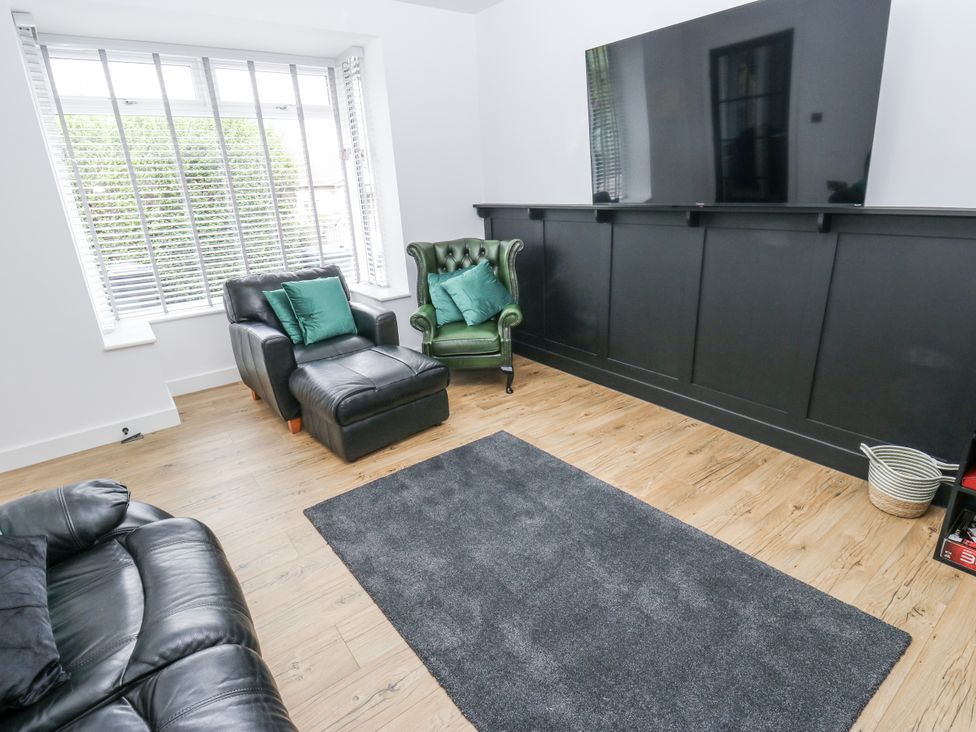 A living room with a sofa and an armchair at Ellis House in Huddersfield