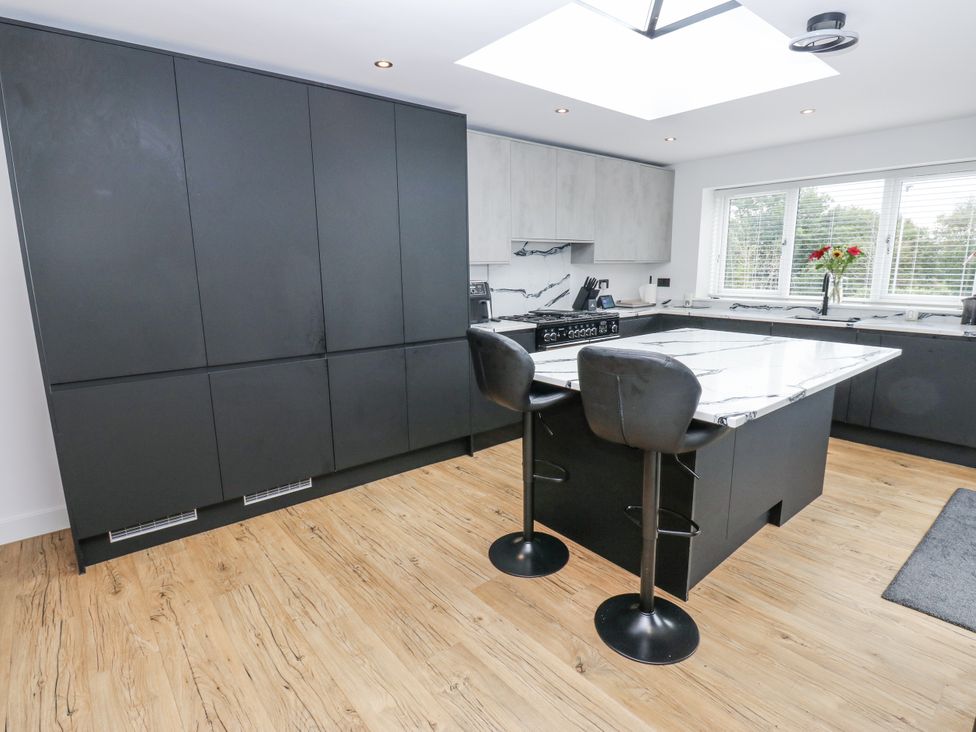 A kitchen with a marble island and black cabinets at Ellis House, Huddersfield