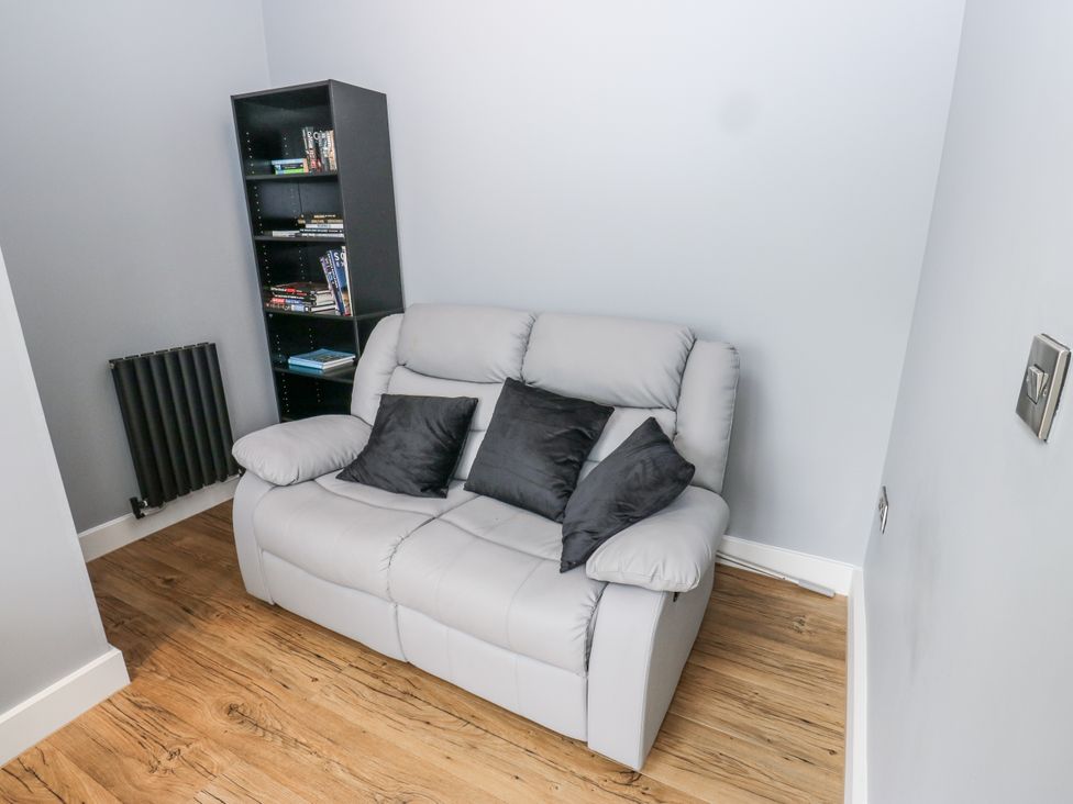 A snug with a sofa and bookshelf at Ellis House in Huddersfield