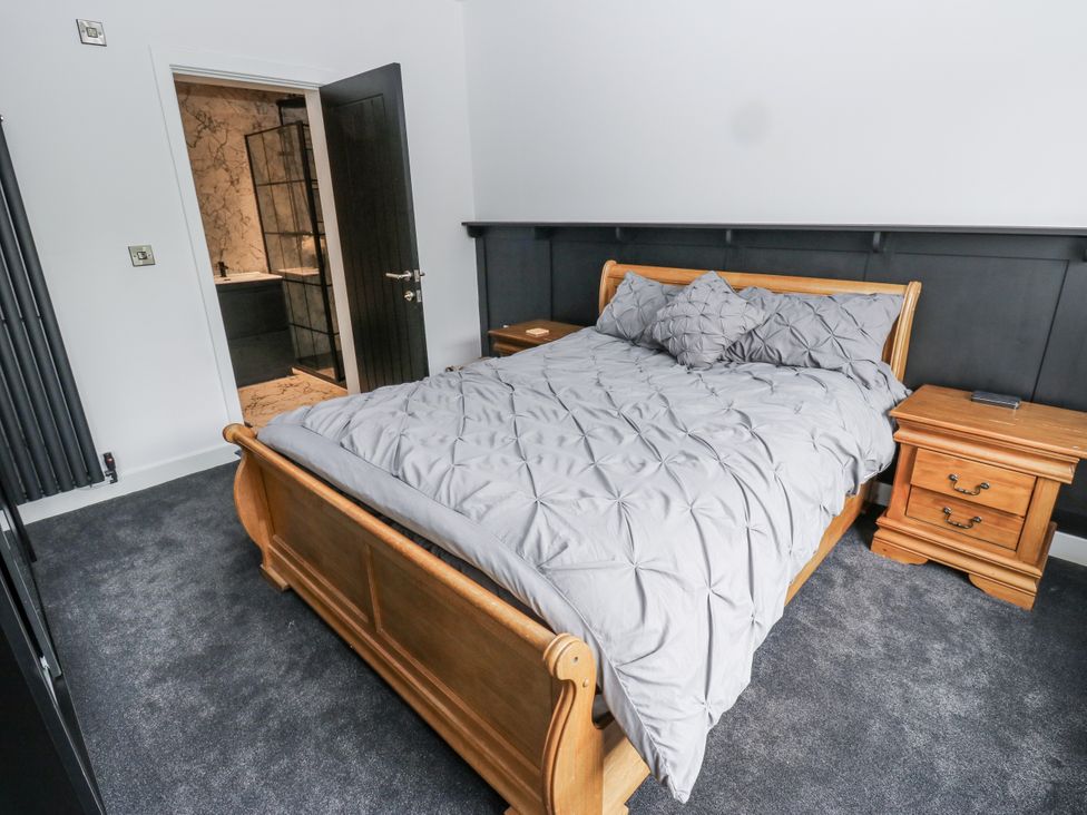 A bedroom with a bed and nightstand at Ellis House in Huddersfield