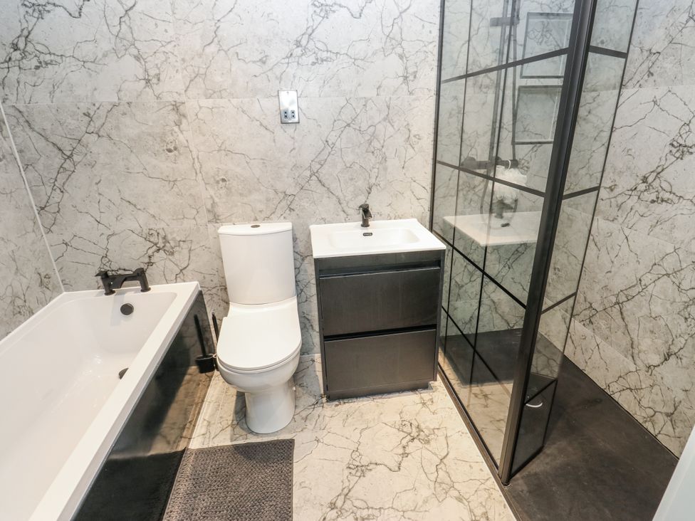 A bathroom with a bathtub, toilet, and sink at Ellis House in Huddersfield