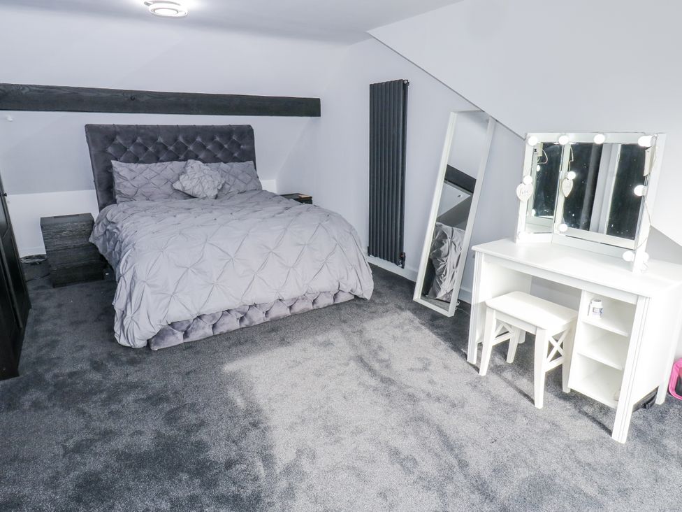A bedroom with a bed and vanity table at Ellis House in Huddersfield
