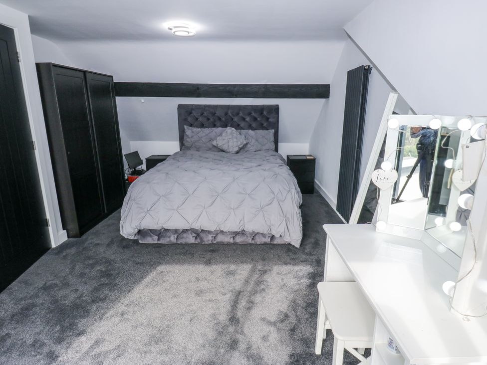 A bedroom with a bed and dressing table at Ellis House in Huddersfield