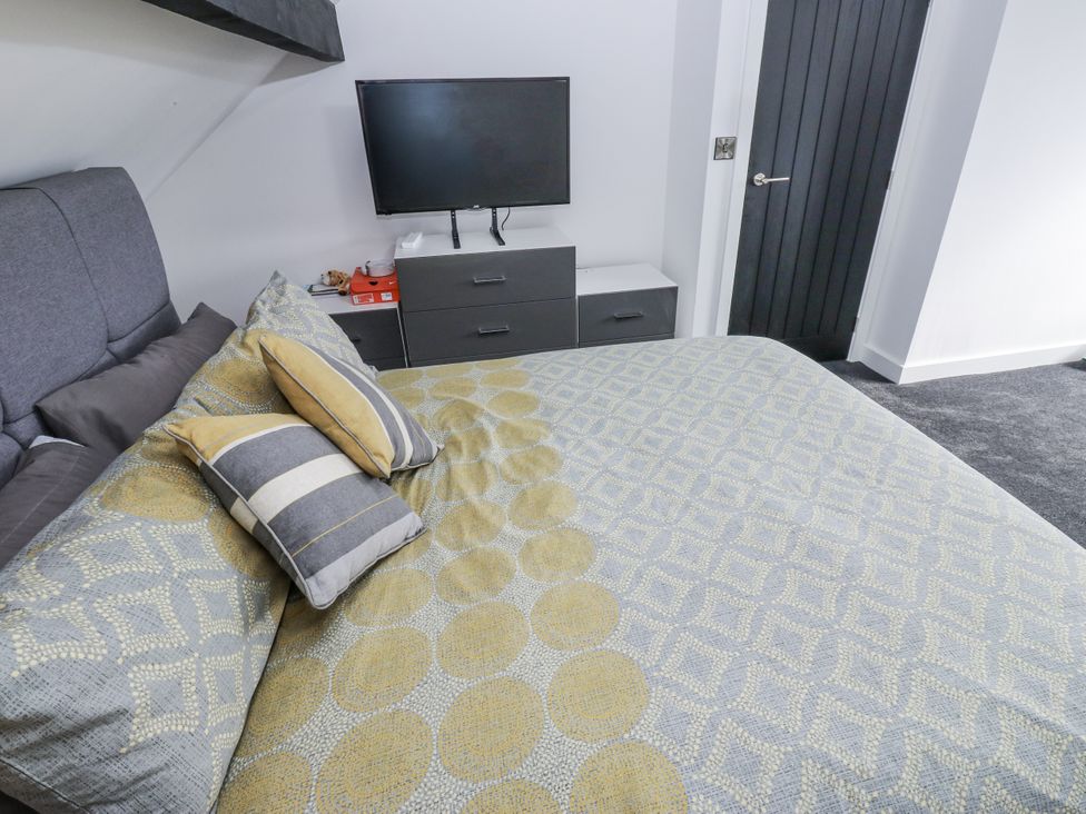 A bedroom with a bed and television at Ellis House in Huddersfield