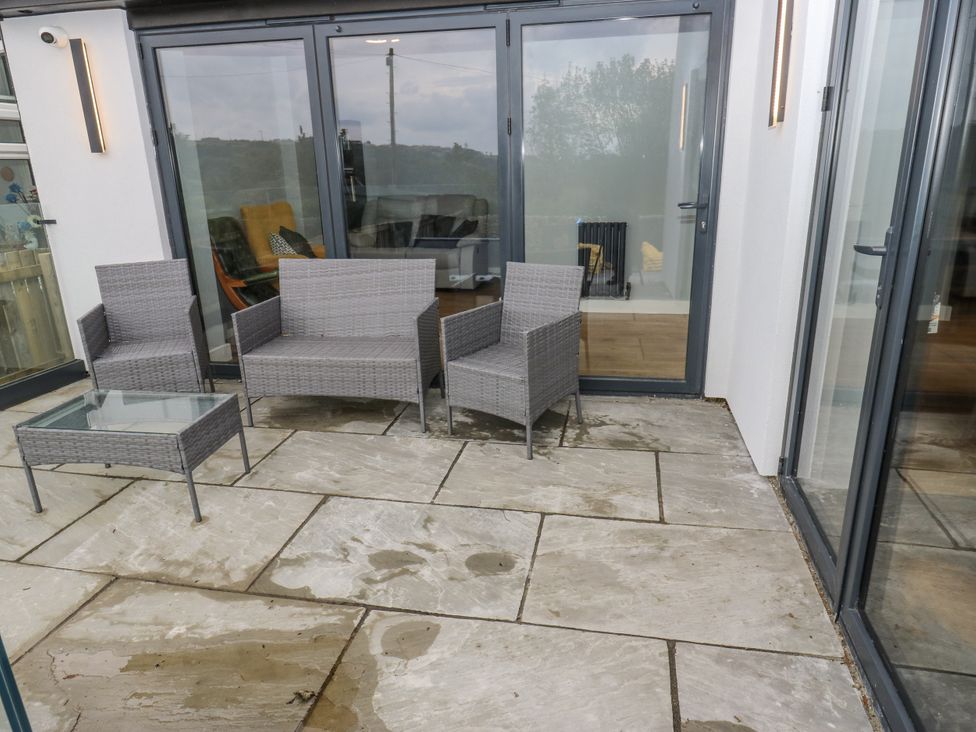 A patio with furniture including chairs and a table at Ellis House in Huddersfield